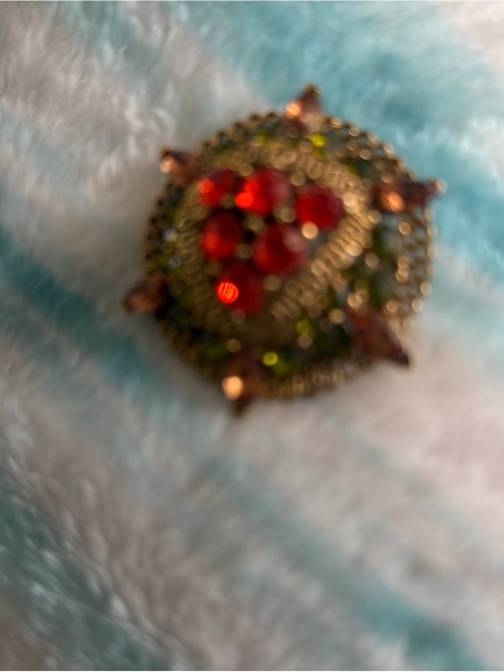 Lisner domed brooch featuring red and green rhinestones in a gold-tone setting.